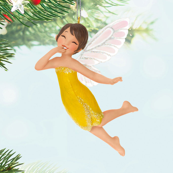Fairy ornament in a yellow dress with white wings on a light blue background