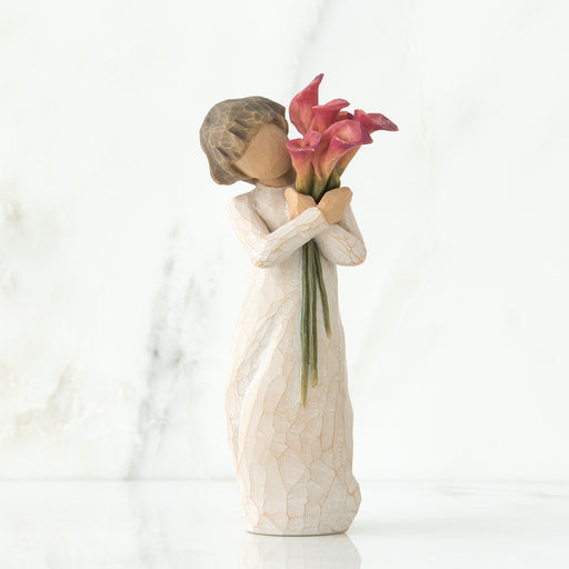 Decorative figurine of a woman holding flowers on a white background
