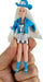 Toy doll with blue outfit and hat held by a hand on a white background