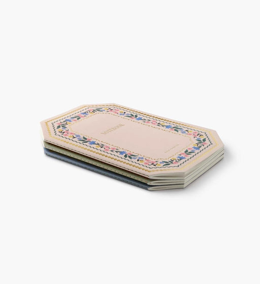 Set of three hexagonal coasters with floral patterns on a white background