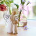 Decorative angel figurine holding a baby with flowers in the background