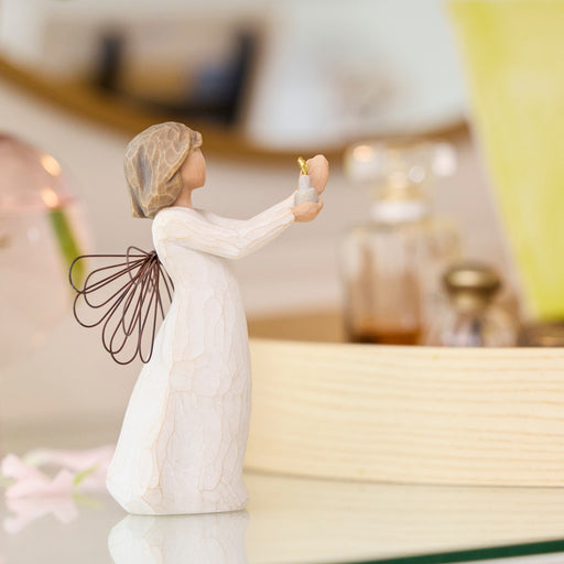 Decorative angel figurine holding a flower in a home setting