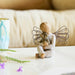 Decorative figurine of a angel holding a teddy bear on a couch