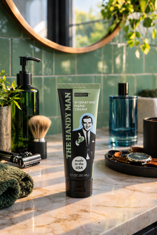 Tube of 'The Handy Man' hand cream on a bathroom counter with grooming products.