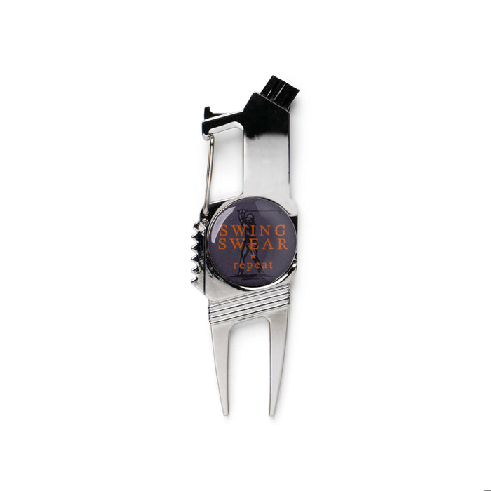 Metallic golf divot tool with 'Swing Swear & Repeat' text on a white background