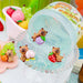 Colorful bear figurines with fruits in a clear container on a colorful background