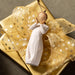 White angel figurine with gold ribbons on a gold gift box