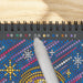 Colorful dot-to-dot book with a hand holding a pen on a wooden surface