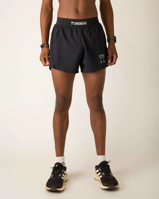 Person wearing black shorts with visible branding on a plain background