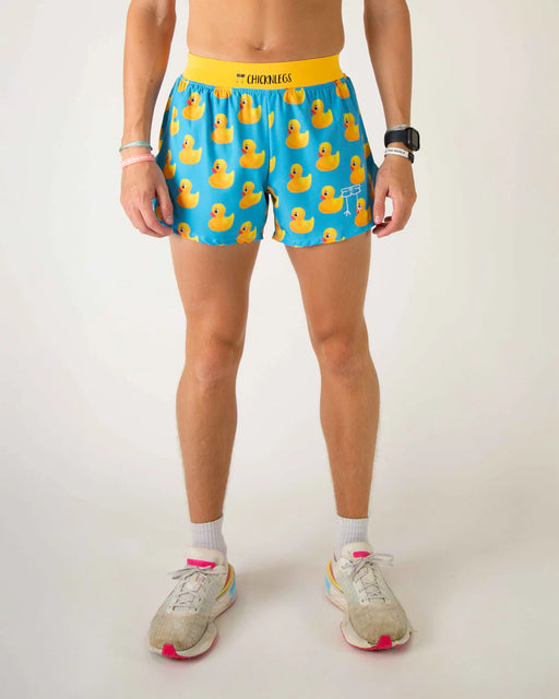 Person wearing blue shorts with yellow rubber duck pattern on a white background