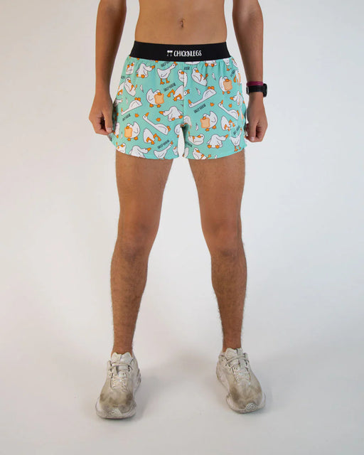 Person wearing teal shorts with cartoon character pattern on a white background
