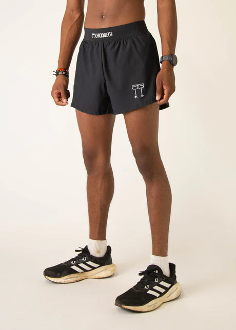 Person wearing black athletic shorts with a logo on a white background