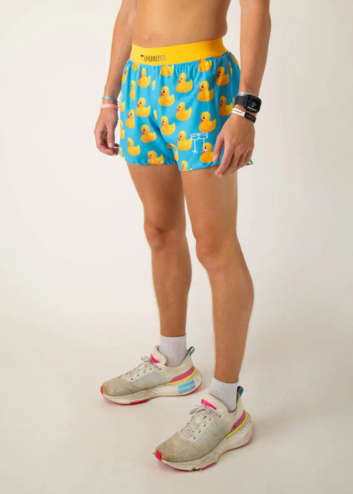 Person wearing blue shorts with rubber duck pattern on a plain background