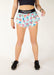 Person wearing colorful patterned shorts with a plain background