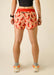 Person wearing red shorts with chili pepper pattern on a plain background