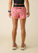 Person wearing pink shorts with banana print on a beige background