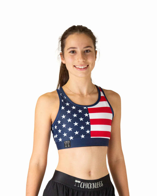 Woman wearing a sports bra with an American flag design on a white background