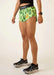 Person wearing green patterned shorts on a plain background