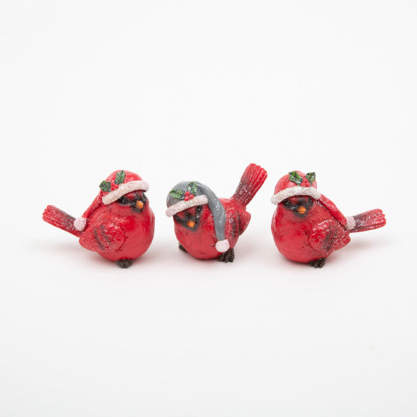 Three red bird figurines wearing Santa hats on a white background