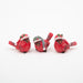 Three red bird figurines wearing Santa hats on a white background