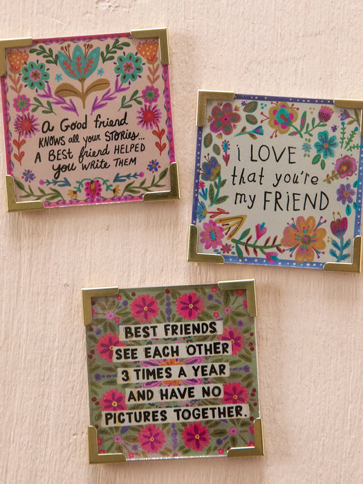 Three floral-themed cards with friendship quotes on a beige background