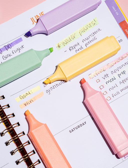 Colorful highlighters on a planner page with notes.