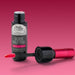 Lip gloss bottle with applicator on a pink background