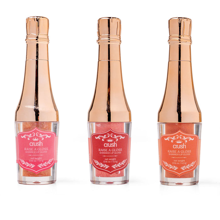 Three bottles of 'crush' hair gloss with rose gold caps on a white background
