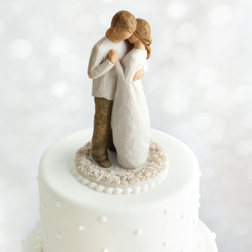 Wedding cake topper with a couple embracing on a white background