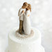 Wedding cake topper with a couple embracing on a white background