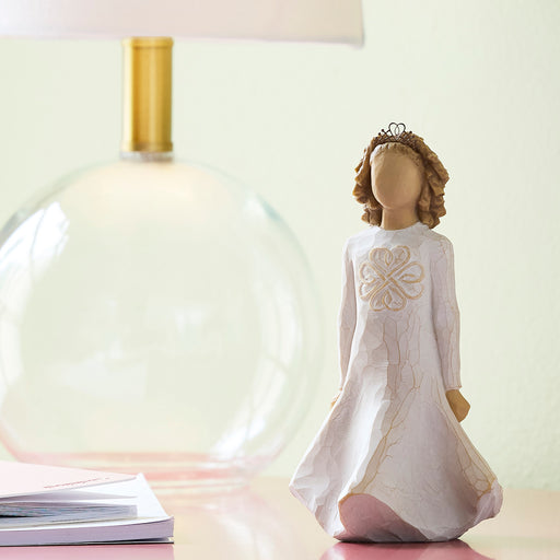 Decorative angel figurine with a white dress and crown on a light background