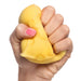 Hand holding a yellow stress ball against a white background