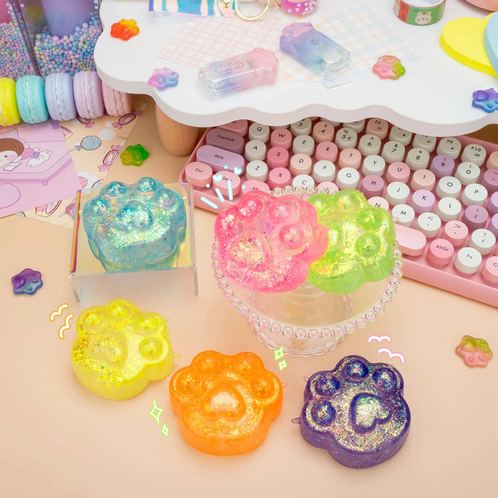 Colorful gelatinous desk accessories on a desk with a keyboard and stationery items.