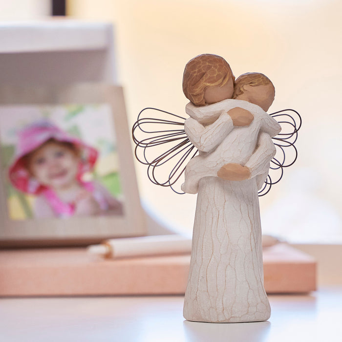 Decorative figurine of two people hugging with a blurred photo frame in the background
