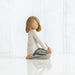 Ceramic figurine of a person sitting with crossed legs on a white background