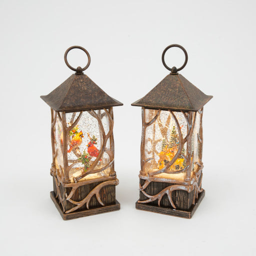 Two decorative lanterns with winter scenes inside on a white background