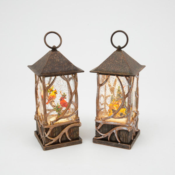 Two decorative lanterns with winter scenes inside on a white background