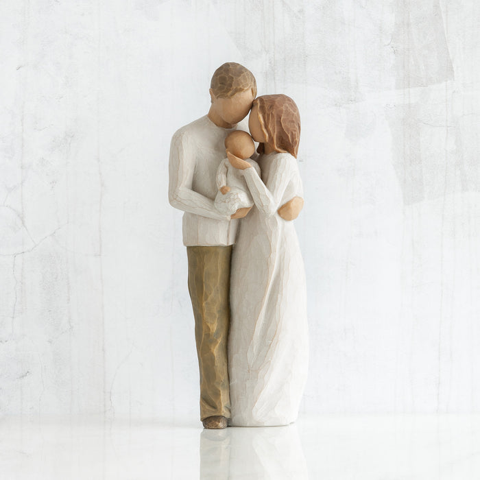 Statue of a couple embracing with a child on a white background