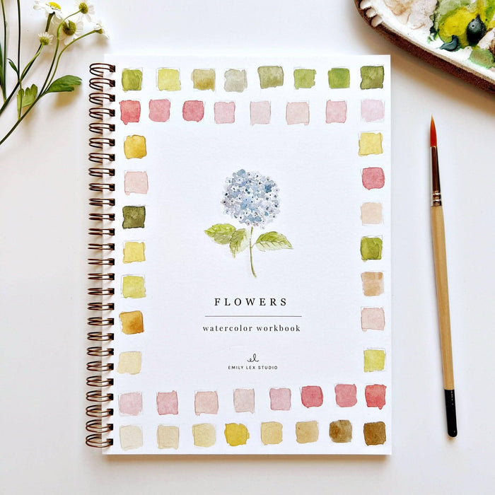 Watercolor workbook titled 'Flowers' with color swatches on a white surface.