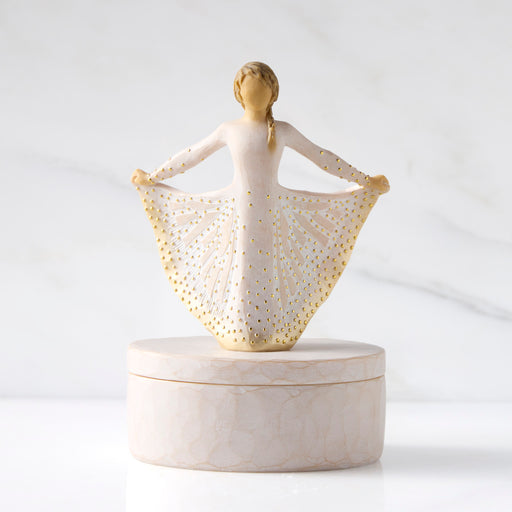 Decorative figurine of a woman with a gold-patterned shawl on a white background