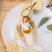 Decorative angel figurine with sunflowers on a yellow and white striped napkin over a white plate.