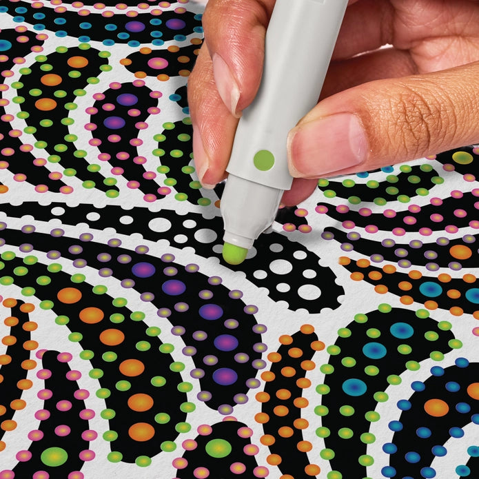 Hand holding a marker over a colorful polka dot pattern