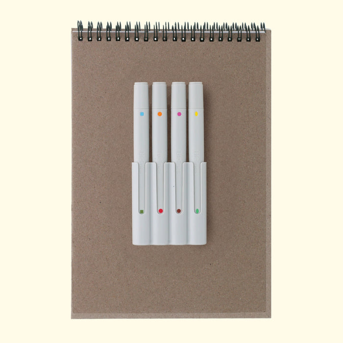 Set of white markers with colored dots on a brown notebook