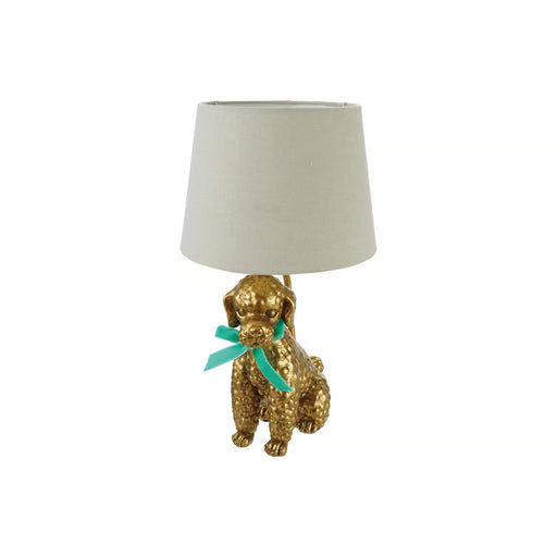 A table lamp featuring a textured gold dog figurine base with a mint green ribbon bow and a light beige fabric drum shade, set against a plain white background.