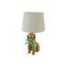 A table lamp featuring a textured gold dog figurine base with a mint green ribbon bow and a light beige fabric drum shade, set against a plain white background.