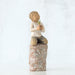 Decorative figurine of a child holding a plant on a textured base against a white background