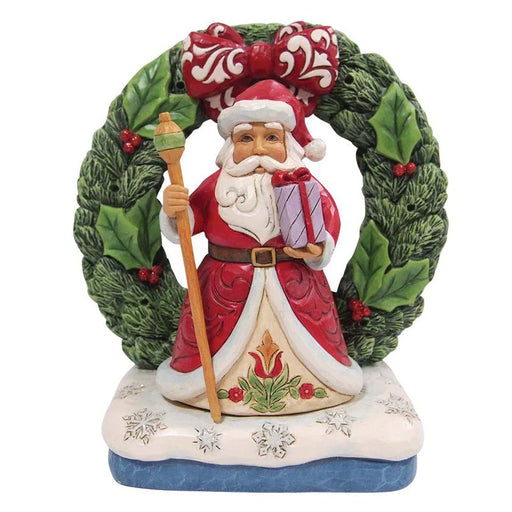 Decorative figurine of Santa Claus with a wreath on a white background