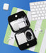 An open black zippered electronics accessory organizer bag displayed on a green and white striped surface, surrounded by a keyboard, earbuds, a charging case, and cables on a blue background.
