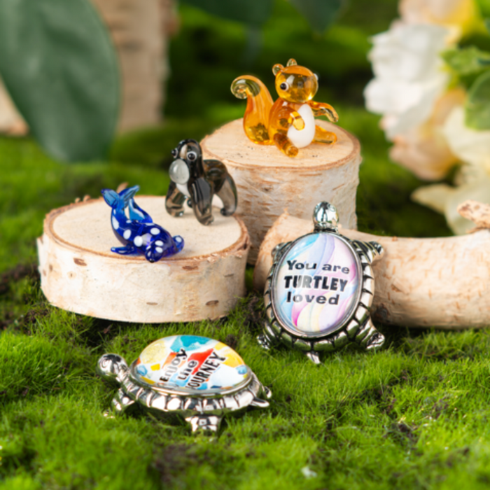 Collection of small figurines and decorative items on a grassy surface