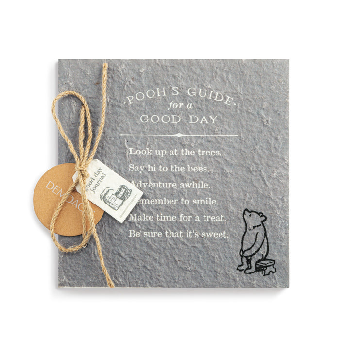 Slate with 'Pooh's Guide for a Good Day' text and a small illustration of Pooh Bear, tied with twine.